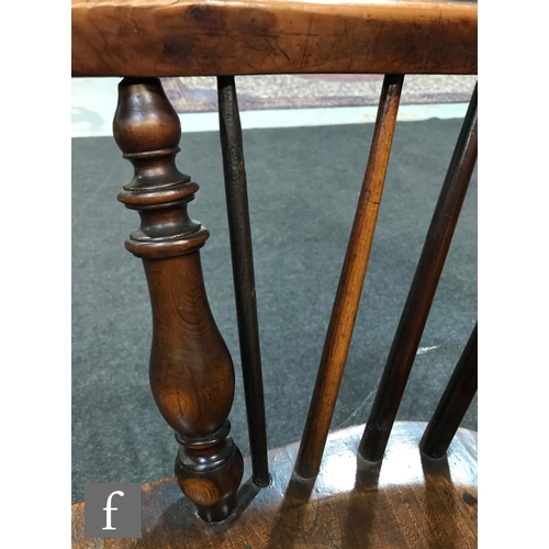 980 - A 19th Century Windsor yew back elbow chair, with elm seat over splayed legs united by a crinoline s... 