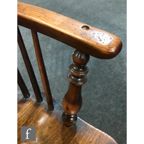 980 - A 19th Century Windsor yew back elbow chair, with elm seat over splayed legs united by a crinoline s... 