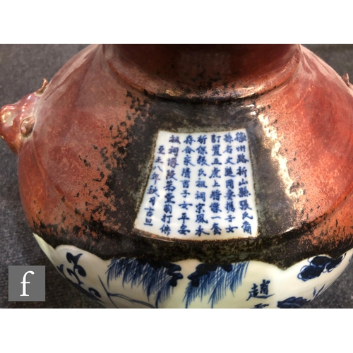 148 - A Chinese flambe ground vase, the heavily potted vase flanked by two relief moulded mask handles, th... 