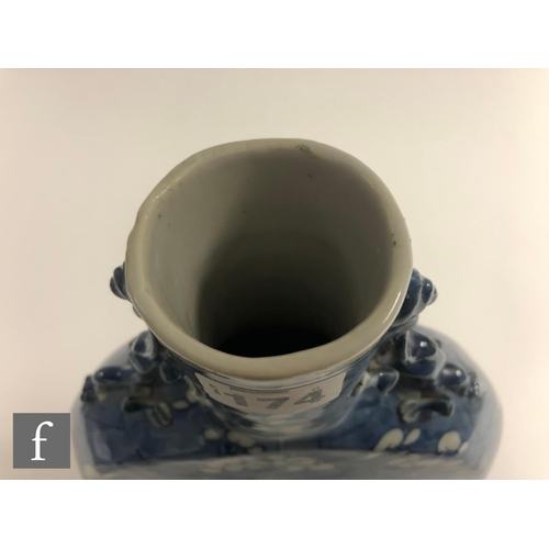 174 - A Chinese 19th Century blue and white 'Prunus' moonflask of rounded form rising from a high footring... 