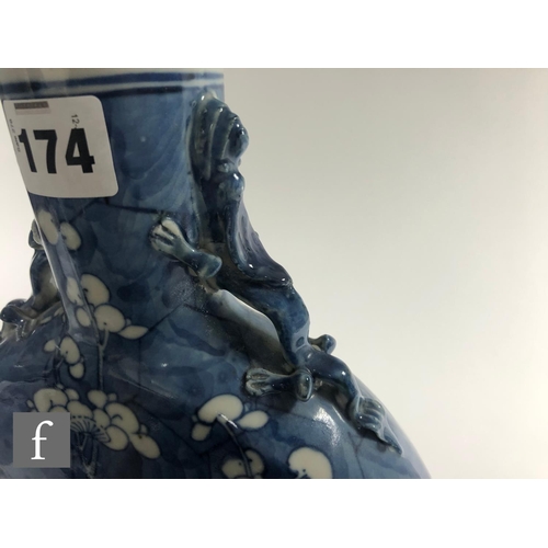 174 - A Chinese 19th Century blue and white 'Prunus' moonflask of rounded form rising from a high footring... 