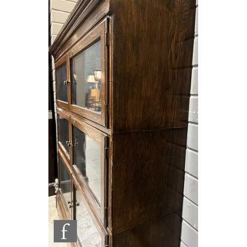 1007 - A pair of oak bookcases in the manner of Minty, each fitted with three glazed double doors over a pl... 