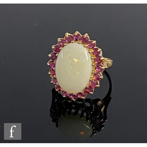 541 - A 9ct hallmarked opal and ruby cluster ring, central oval opal within a border of rubies, weight 3.6... 