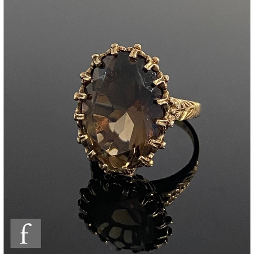 547 - A 9ct hallmarked single stone smoky quartz ring, claw set stone to flower head detailed shoulders, w... 