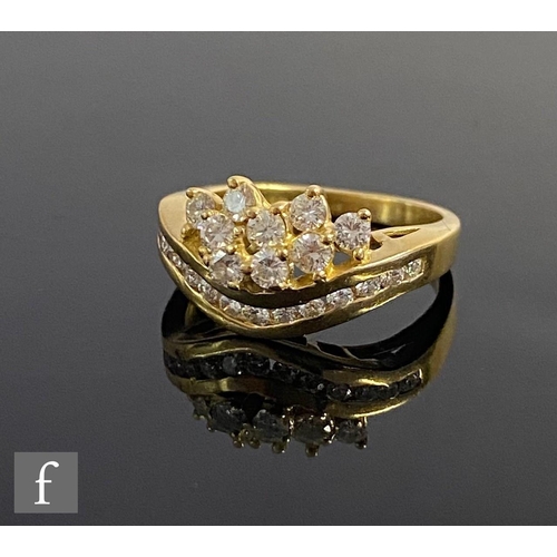 548 - An 18ct hallmarked diamond cluster ring, a waved row of channel set stones below a cluster of nine b... 