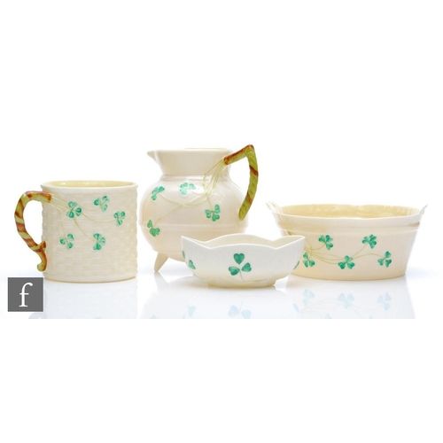 9010 - Four pieces of Belleek comprising a jug formed as a cauldron, a small mug, an open salt and a sugar ... 