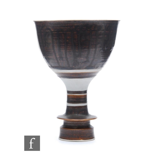 9018 - A mid 20th Century studio pottery goblet or chalice decorated in a brown dribble glaze with a shaped... 