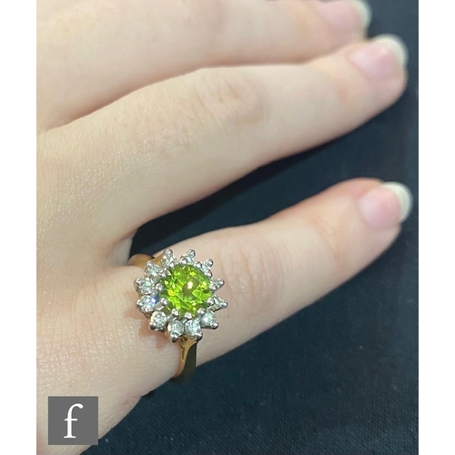 440 - An 18ct hallmarked peridot and diamond cluster ring, central peridot within a border of twelve brill... 