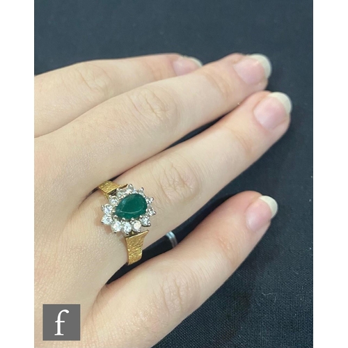 443 - An 18ct emerald and diamond cluster ring, central pear shaped emerald within a border of twelve bril... 