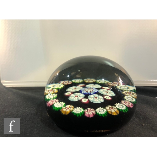 247 - A Scottish Perthshire paperweight with a central rosette of millefiori canes within a matched border... 