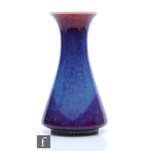 103 - Ruskin Pottery - A high fired vase of flared form decorated in a tonal lavender with paler curtain a... 