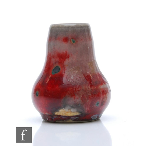 110 - Ruskin Pottery - A miniature high fired vase of globe and shaft form decorated in a tonal flambe gla... 