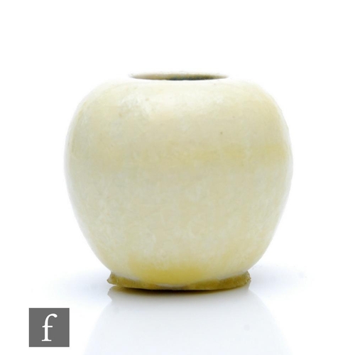 113 - Ruskin Pottery - A miniature vase of globular form decorated in a pale yellow with pale crystalline ... 