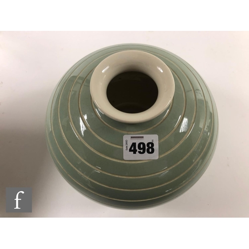 498 - Keith Murray - Wedgwood - A vase of footed compressed spherical form glazed in celadon over white wi... 