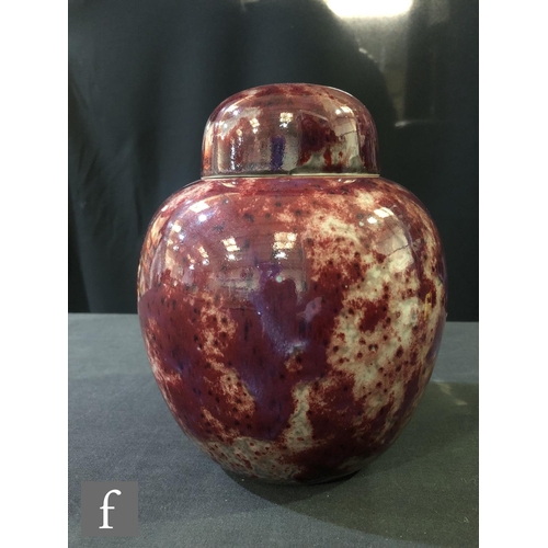 108 - Ruskin Pottery - A high fired globular vase and cover decorated in a mottled sang de boeuf with dark... 