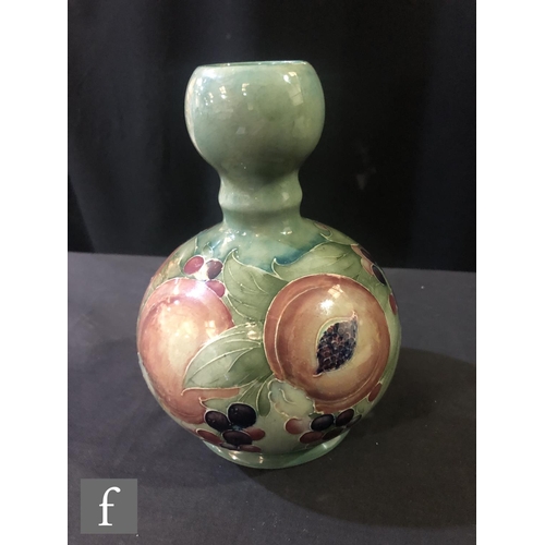 166 - William Moorcroft - A double gourd vase decorated in the Pomegranate pattern with a band of open and... 