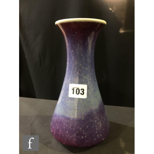 103 - Ruskin Pottery - A high fired vase of flared form decorated in a tonal lavender with paler curtain a... 