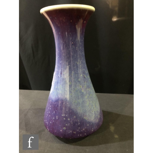 103 - Ruskin Pottery - A high fired vase of flared form decorated in a tonal lavender with paler curtain a... 