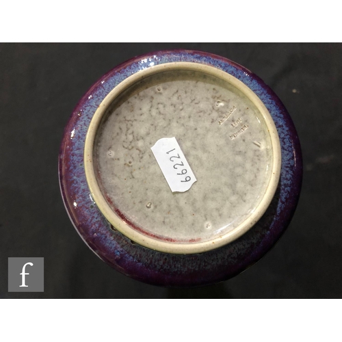 103 - Ruskin Pottery - A high fired vase of flared form decorated in a tonal lavender with paler curtain a... 