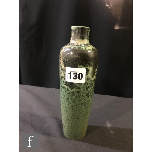 130 - Ruskin Pottery - A high fired vase of slender tapering form decorated in a tonal green with fissurin... 