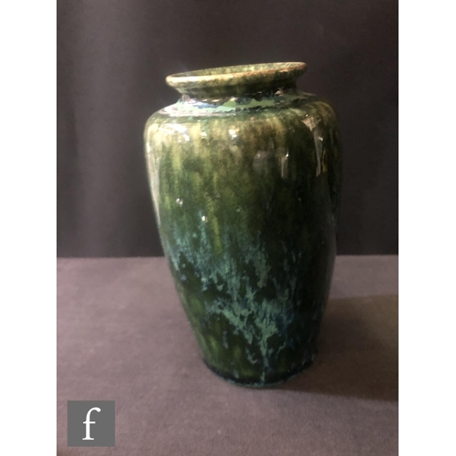 124 - Ruskin Pottery - A small souffle glazed vase of swollen form decorated in a mottled green with tonal... 