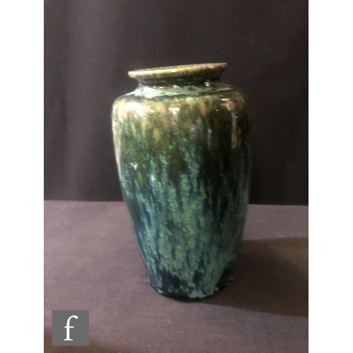 124 - Ruskin Pottery - A small souffle glazed vase of swollen form decorated in a mottled green with tonal... 