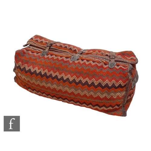 169 - An Oman Bedouin camel woven travel bag, the large woven bag in vibrant orange, white and umber tones... 