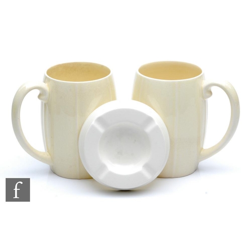 113 - Two Keith Murray for Wedgwood tankards in cream with vertical ribbed bands, printed signature mark, ... 