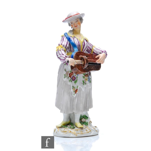 143 - A 19th Century Meissen figure of a lady stood playing a Hurdy Gurdy, dressed in a striped bodice wit... 