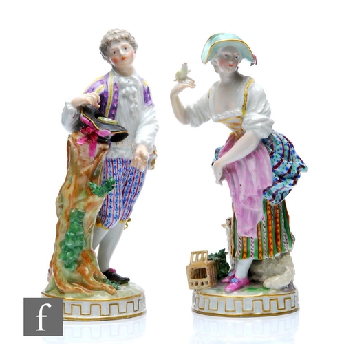 148 - A pair of 19th Century Meissen figures after the original by M.V. Acier, she stood in a patterned bo... 