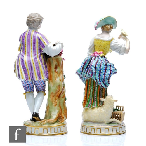 148 - A pair of 19th Century Meissen figures after the original by M.V. Acier, she stood in a patterned bo... 