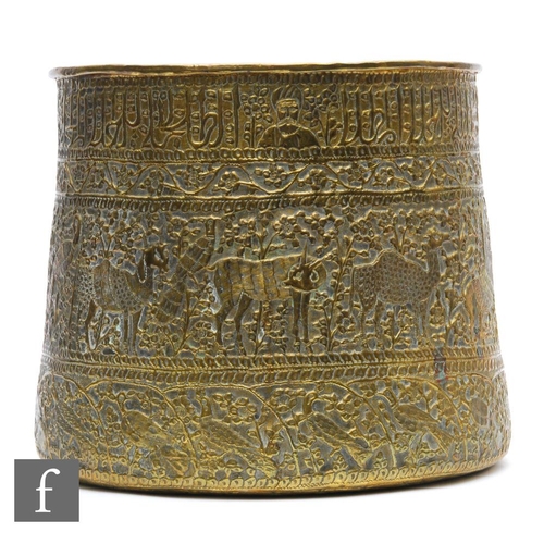 150 - An early 20th Century pressed brass Indian jardinière, decorated all over with figures, animals, bir... 