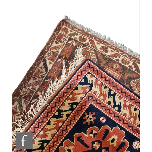 154 - Two Asian rugs, to include a Kuba style prayer rug, with salmon pink and blue designs, 128cm x 103cm... 