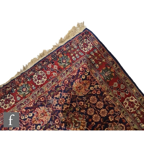 155 - A Khorassan style rug, the dark blue ground with red, green and ochre floral designs, 198cm x 122cm.