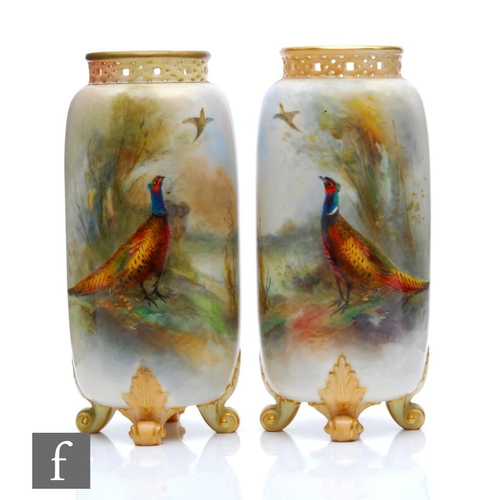 28 - A pair of early 20th Century Royal Worcester shape G42 vases of cylindrical form raised to four scro... 