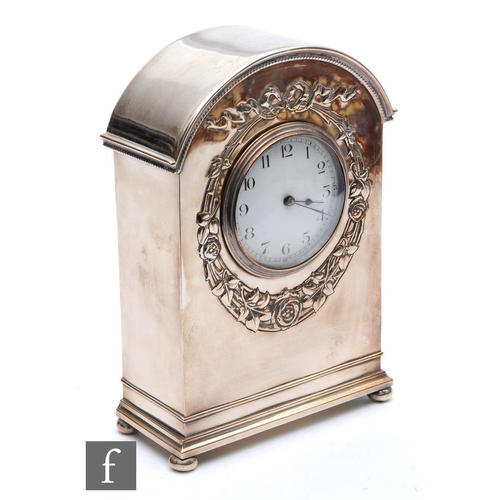 494 - An Edwardian plated mantle clock in the Art Nouveau style, the domed top over a white enamelled dial... 