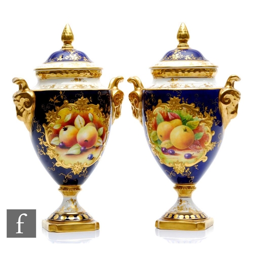 53 - A matched pair of Coalport pedestal vases each decorated with hand painted cartouche panels of fruit... 