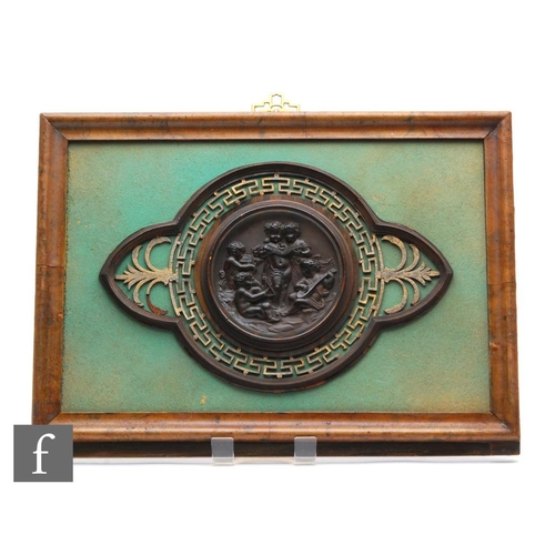 543 - A 19th Century bronzed circular plaque of putti playing instruments within a Greek Key pierced later... 