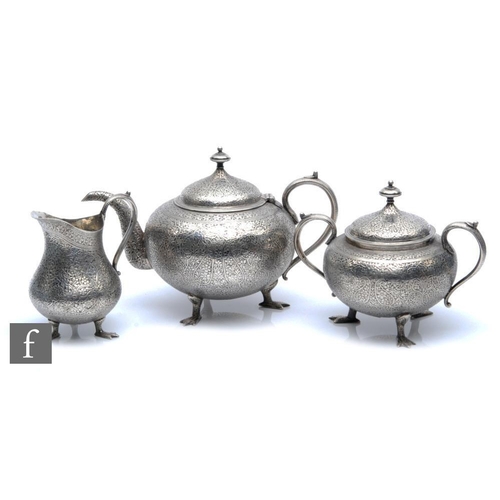 286 - An early 20th Century white metal three piece tea set with foliate decoration and each terminating i... 