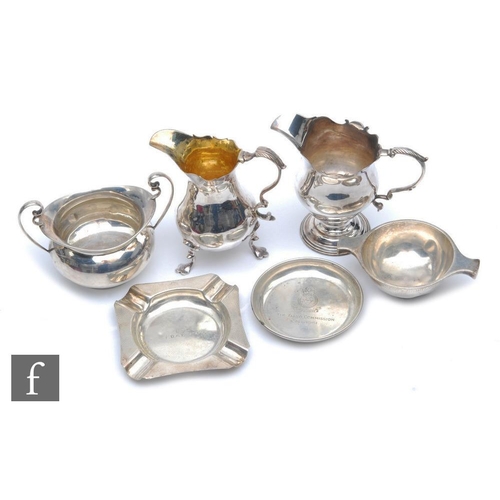 296 - Two George III cream jugs, marks rubbed, a sugar basin, an engine turned ash tray, a small circular ... 