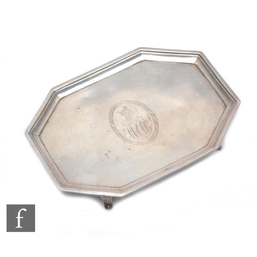 297 - A George III octagonal teapot stand, engraved with a crest and monogrammed, raised border, on splaye... 