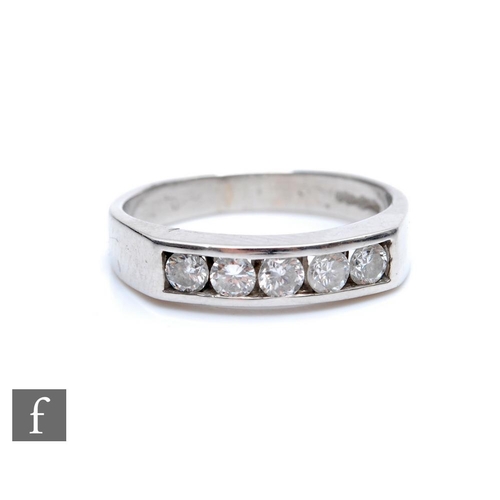 357 - A platinum hallmarked diamond five stone ring, channel set brilliant cut stones to a plain shank, we... 