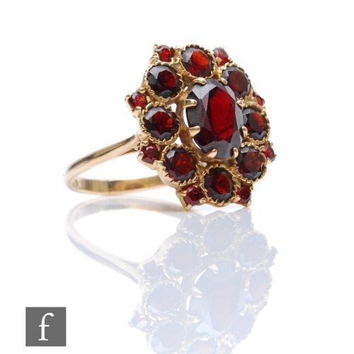 377 - A 9ct hallmarked garnet cluster ring, comprising claw and collar set stones, weight 4.9g, ring size ... 