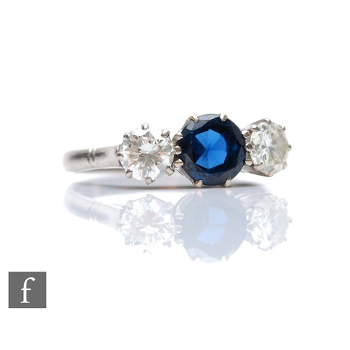 381 - An 18ct white gold sapphire and diamond three stone ring, central circular sapphire flanked with a b... 