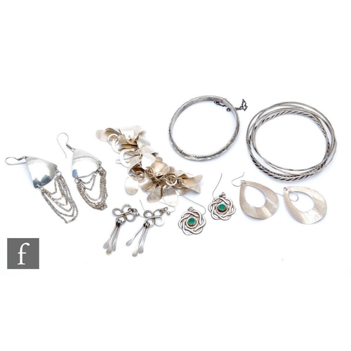 418 - A collection of silver jewellery comprising five bangles, four pairs of earrings, a bracelet and a V... 