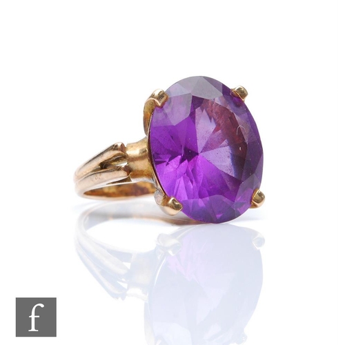 428 - A 14k gold dress ring set with a facet cut amethyst coloured stone in a claw setting.