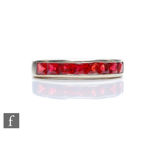 358 - A 9ct white gold red stone half eternity ring comprising channel set square cut stones, weight 2.8g,... 