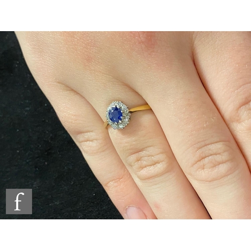 376 - An 18ct sapphire and diamond cluster ring, central oval sapphire within a diamond set border, weight... 