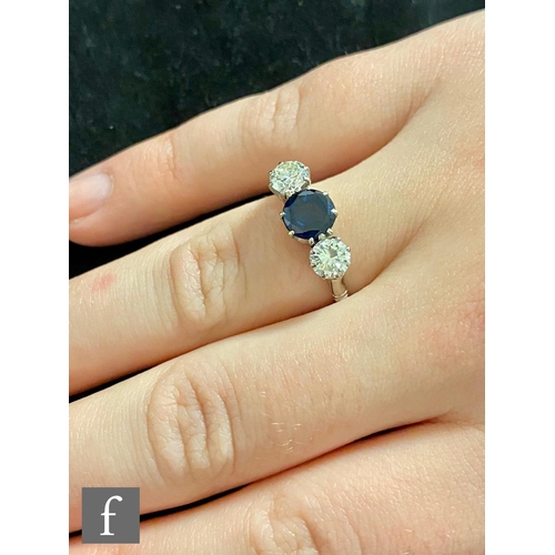 381 - An 18ct white gold sapphire and diamond three stone ring, central circular sapphire flanked with a b... 