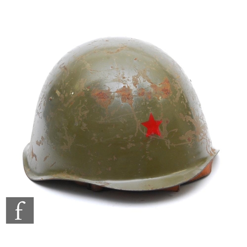 998 - A 1960s Czech Soviet combat helmet, painted green with red star decal, original lining and chin stra... 